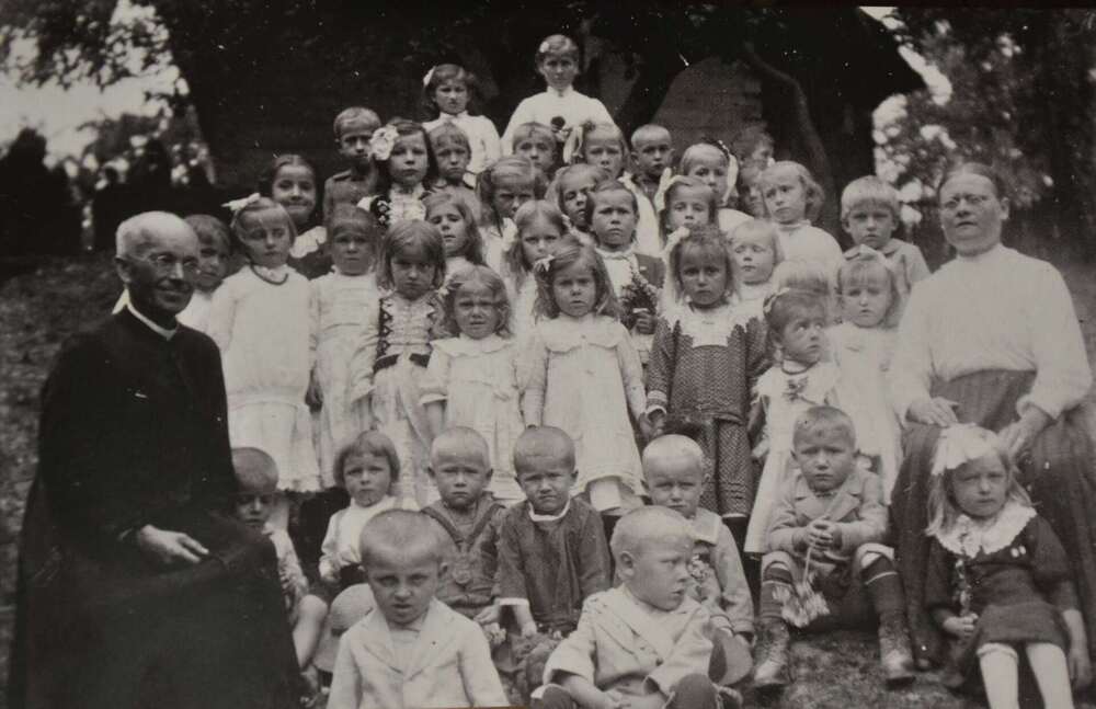 Ksiądz dr Franciszek Gołba pośród dzieci z ochronki w Bachowicach, z prawej – opiekunka Maria Momot. Fotografia ze zbiorów Kazimierza Dębskiego (Archiwum Gminnej Biblioteki Publicznej w Spytkowicach)