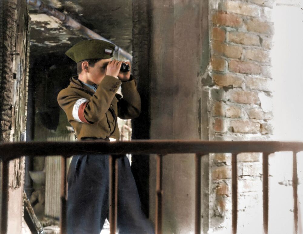 Do walki stanęły również warszawskie dzieci. Pełniły służbę jako łącznicy, przewodnicy w kanałach, niszczyły butelkami z benzyną niemieckie czołgi, z bronią w ręku pełniły służbę liniową na barykadach. Fot. Ze zbiorów Muzeum Powstania Warszawskiego, koloryzacja: Mikołaj Kaczmarek