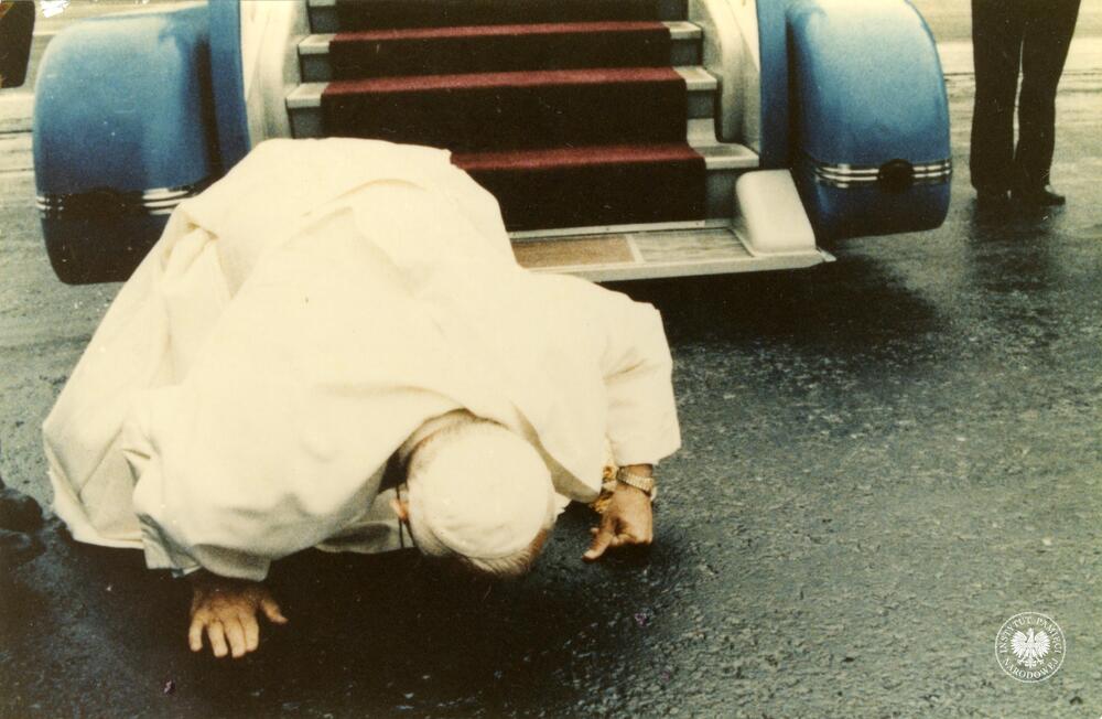 Jan Paweł II całuje ziemie na płycie lotniska Okęcie w Warszawie po wyjściu z samolotu, 16 VI 1983 r. (fot. z zasobu AIPN)