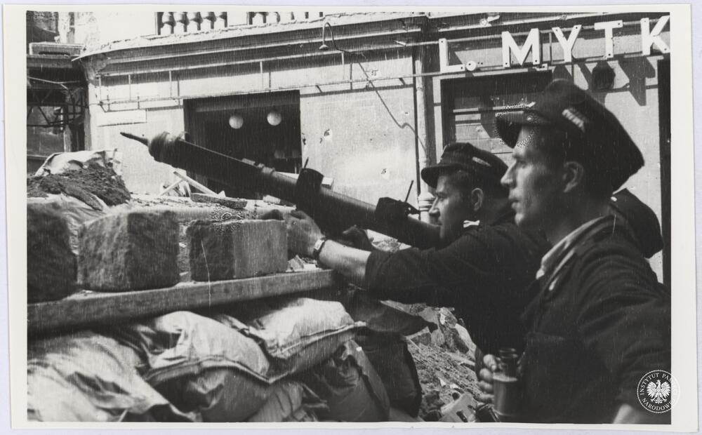 Kilku niezidentyfikowanych powstańców z nieustalonego oddziału AK na barykadzie na ul. Chmielnej między Hotelem Astoria a narożną kamienicą, fot. H. Śmigacz, z zasobu Aruchiwum IPN, sygn. IPNBU-2-21-26-3-1