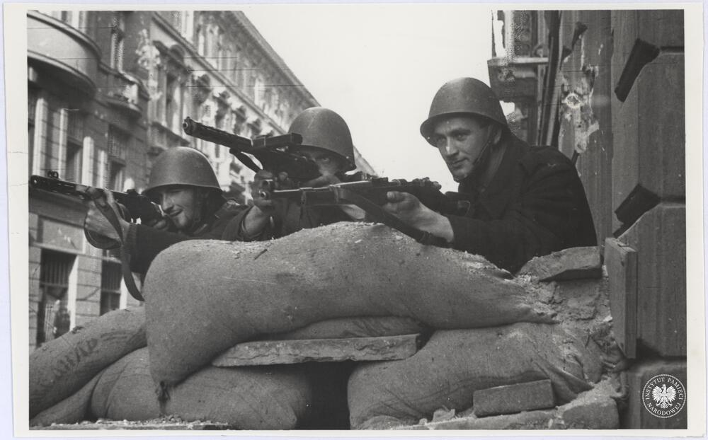 Trzech niezidentyfikowanych powstańców z nieustalonego oddziału AK stoi na jednej z ulic w Śródmieściu Północnym, fot. Henryk Śmigacz, z zasobu Archiwum IPN, sygn. IPNBU-2-21-28-3-1