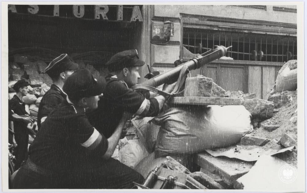 Kilku niezidentyfikowanych powstańców z nieustalonego oddziału AK na barykadzie na ul. Chmielnej między Hotelem Astoria a narożną kamienicą, fot. H. Śmigacz, z zasobu Aruchiwum IPN, sygn. IPNBU-2-21-26-4-1