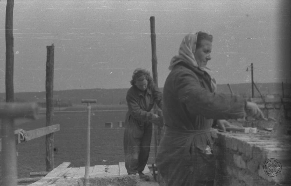 IPNBy-23-5-3-6, Prace budowlane przy jednej ze ścian budynku (widoczne: 2 NN kobiety murujące ścianę). Źródło: AIPN