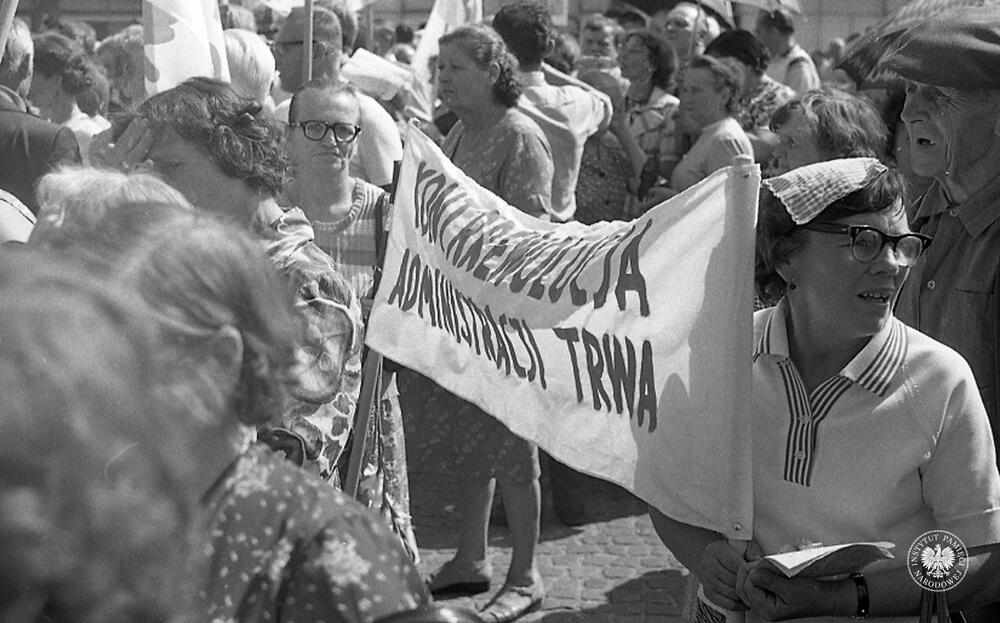 Ujęcie części protestujących przed budynkiem KW PZPR na ul. E. Próchniaka (obecnie ul. W. Liniarskiego). Na pierwszym planie transparent o treści "Kontrrewolucja administracji trwa", fot. AIPN, sygn. IPNBi-3-9-1-52.