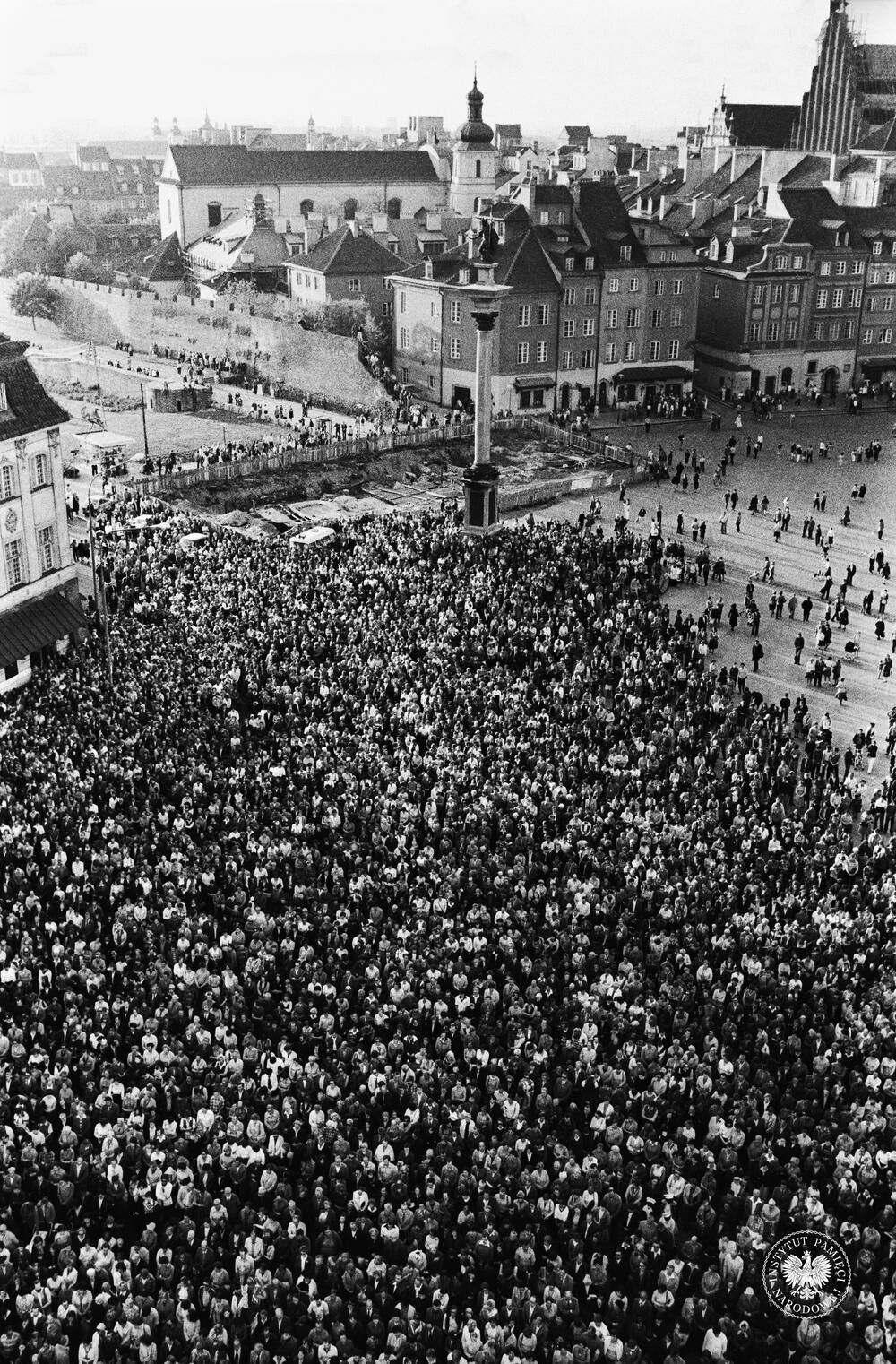 Ludzie zebrani na placu Zamkowym w Warszawie po zamachu na papieża Jana Pawła II. W głębi widoczna kolumna króla Zygmunta III Wazy, z zasobu AIPN, sygn. IPNBU-10-5-39-124-1