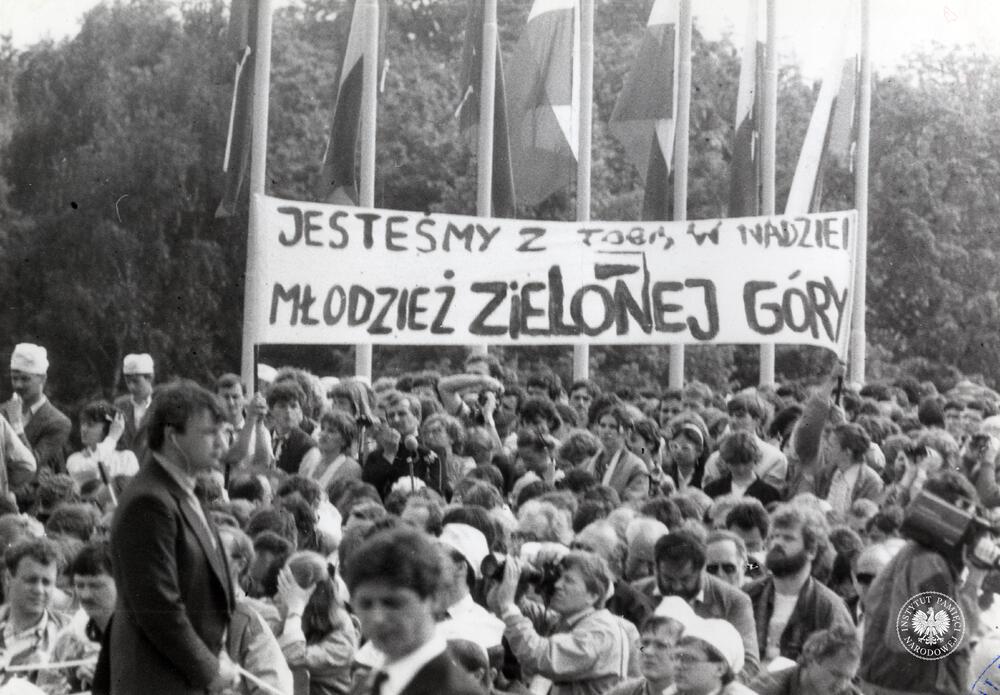 Trzecia pielgrzymka Jana Pawła II do Polski. Ludzie zgromadzeni na Westerplatte podczas wizyty Jana Pawła II w Gdańsku w 1987 r. Na widocznych transparentach napis: „Jesteśmy z Tobą w nadziei / Młodzież Zielonej Góry”, z zasobu AIPN, sygn.  IPNGd-7-2-2-17-1