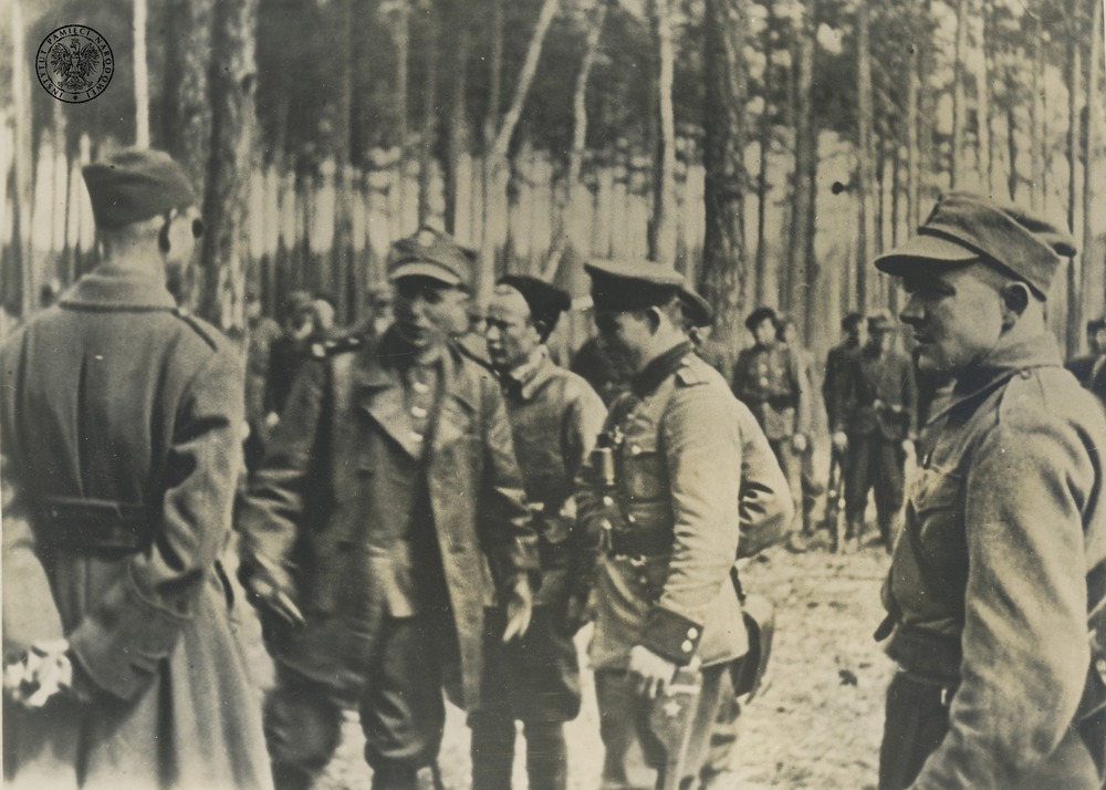 Dowódca 27. Wołyńskiej Dywizji Piechoty AK major dypl. Jan Wojciech Kiwerski ps. Oliwa (prawdopodobnie drugi od lewej) i towarzyszący mu oficerowie podczas rozmów z oficerami partyzantki sowieckiej (w tym z dowódcą sowieckiego oddziału pułkownikiem Fiodorowem – drugi od prawej) w kwietniu 1944 r. Odbitka (reprodukcja) rozpowszechniana przez komórki propagandy rządu RP na uchodźstwie, pochodząca z kolekcji p. Teresy Mellerowicz-Gelli (fot. z zasobu IPN)