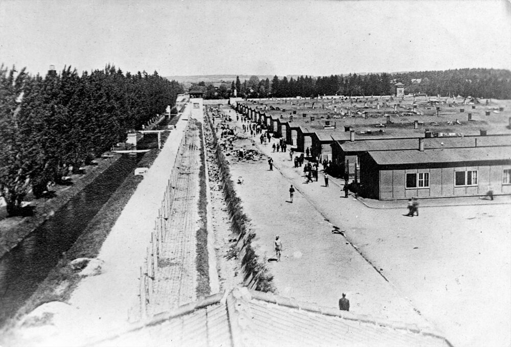 Widok na obóz KL Dachau po wyzwoleniu obozu przez wojska amerykańskie. Z lewej ogrodzenie i wieże strażnicze. Po prawo baraki mieszkalne. Fot. AIPN