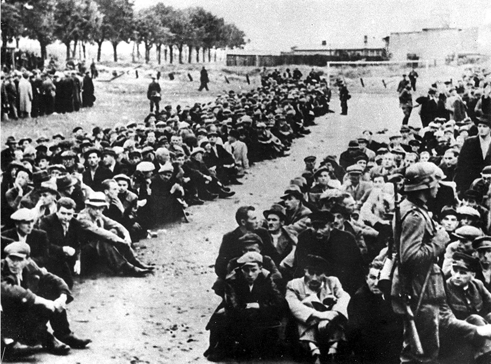 Osoby aresztowane w Gdyni oczekujące na przeprowadzenie do obozu przejściowego w Gdyni Grabówku, wrzesień 1939 r. (fot. NAC)