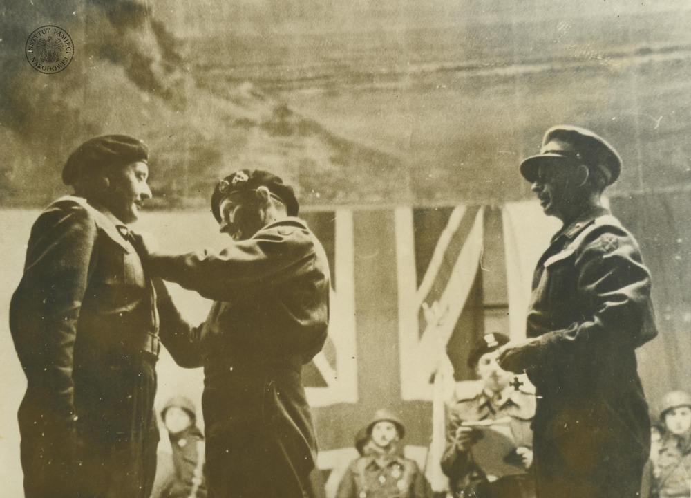 Dowódca 21. Grupy Armii marsz. polny Bernard Montgomery (drugi od lewej) przypina odznaczenie dowódcy polskiej 1. Dywizji Pancernej PSZ gen. bryg. Stan. Maczkowi. Breda, 25 listopada1944 r. Po prawej stoi najprawdopodobniej dowódca 1. Armii Kanadyjskiej gen. Henry „Harry” Crerar. Odbitka rozpowszechniana przez komórki propagandy Rządu RP na uchodźstwie, pochodząca z kolekcji Teresy Mellerowicz-Gelli (fot. z zasobu AIPN)