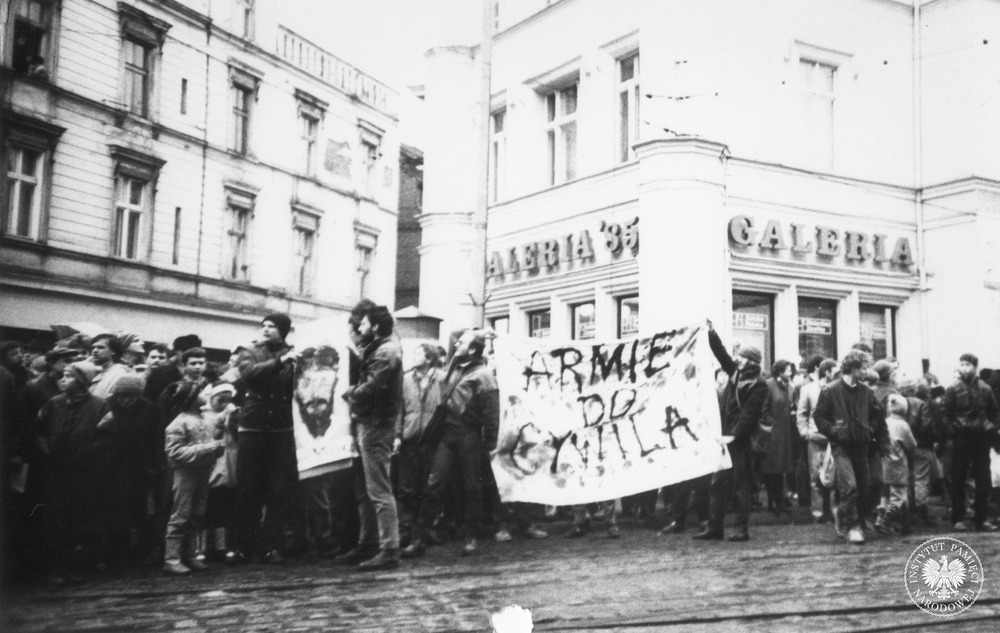 Działacze Ruchu „Wolność i Pokój” podczas demonstracji z transparentem „Armie do cywila” i podobizną Sławomira Dutkiewicza, uwięzionego za odmowę służby wojskowej. Bydgoszcz, 8 II 1988 r. (fot. z zasobu IPN)