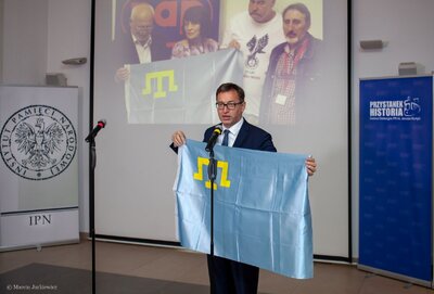 Prezes IPN dr Jarosław Szarek dziękuje za flagę otrzymaną od przedstawicieli narodu Tatarów Krymskich będącą wyrazem wdzięczności za zorganizowanie konferencji przypominającej współpracę SW z organizacjami narodowymi z byłych republik sowieckich. Fot. Marcin Jurkiewicz.