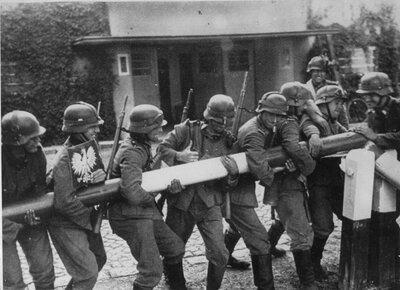 Niemieccy żołnierze inscenizują dla celów propagandowych scenę łamania polskiego szlabanu granicznego w Kolibkach. Wrzesień 1939 r. (AIPN)