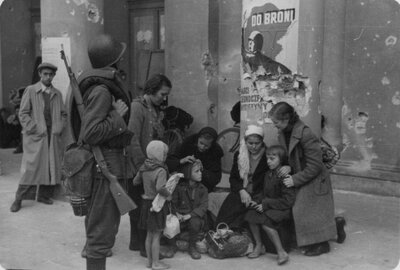 Kobiety z dziećmi szukają schronienia pod arkadą gmachuTeatru Wielkiego w Warszawie, około 15 września 1939 roku. (AIPN/Kolekcja Juliena Bryana w Warszawie)