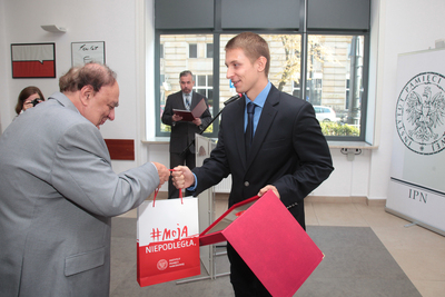 Mateusz Hübner otrzymuje nagrodę z rąk dr. Andrzeja Koryna. Fot. Piotr Życieński (IPN)