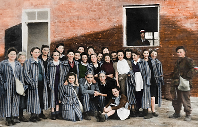 Więźniowie „Gęsiówki” wraz ze swoimi wyzwolicielami. Fot. Juliusz B. Deczkowski/domena publiczna; koloryzacja: Mikołaj Kaczmarek