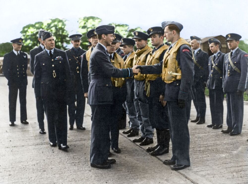 Wizyta króla Jerzego VI 26 września 1940 r. w Dywizjonie 303. Król ściska dłoń ppor. Mirosławowi Fericiowi. Obok ppor. Jan Zumbach. Chwilę po wyjeździe króla Dywizjon został znów poderwany do walki. Fot. Ze zbiorów Roberta Gretzyngiera; koloryzacja: Mikołaj Kaczmarek