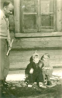 Mjr Zygmunt Szendzielarz „Łupaszka” przed drewnianym domem w Olczy. Obok niego siedzi na sankach dwójka dzieci – po lewej syn Lucjana i Wandy Minkiewiczów Andrzej, po prawej Zofia Zwijacz – luty 1948 (AIPN)