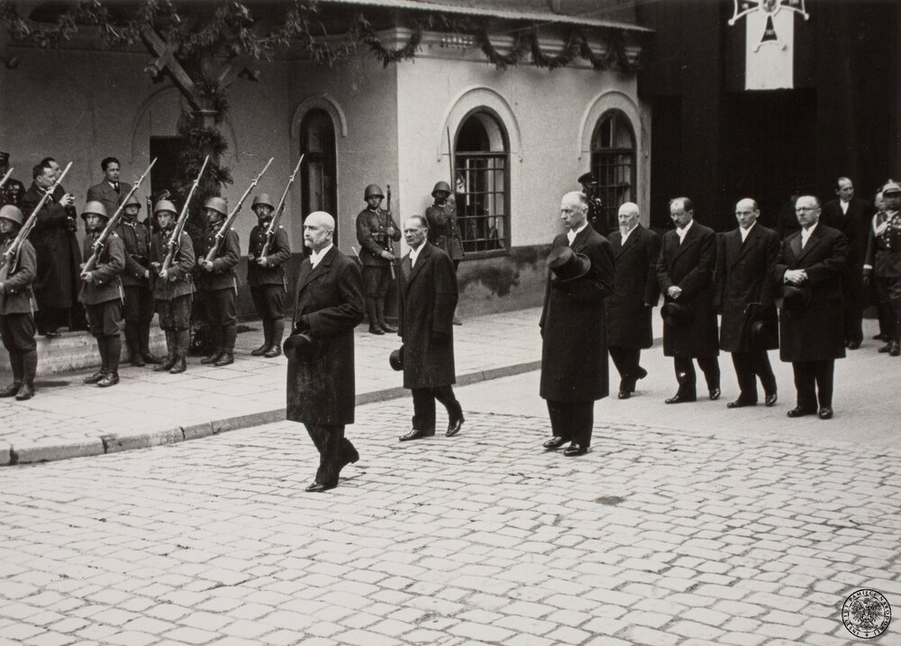 Kraków, uroczystości pogrzebowe J. Piłsudskiego, 18 maja 1935. Politycy polscy w kondukcie przez symboliczną bramę przy Dworcu Głównym. Na czele Walery Sławek, premier rządu RP, za nim z lewej Kazimierz Świtalski (Marszałek Sejmu RP), obok Władysław Raczkiewicz (Marszałek Senatu RP); dalej w jednym szeregu 4 byłych premierów RP, od lewej - Aleksander Prystor, Leon Kozłowski, Janusz Jędrzejewicz i Kazimierz Bartel. Na drugim planie Józef Beck, minister spraw zagranicznych RP. Fot. z zasobu IPN