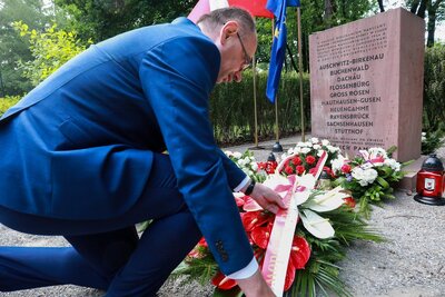 Wiązanka przy kamieniu upamiętniającym Mieszkańców Warszawy Cywilów i Powstańców, którzy podczas Powstania Warszawskiego zostali wywiezieni i zamordowani w obozach koncentracyjnych – 1 sierpnia 2021. Fot. Sławek Kasper (IPN)