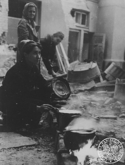 Kobiety nabierające wodę na jednej z ulic w czasie Powstania Warszawskiego (AIPN)