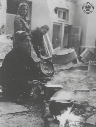 Kobiety nabierające wodę na jednej z ulic w czasie Powstania Warszawskiego (AIPN)