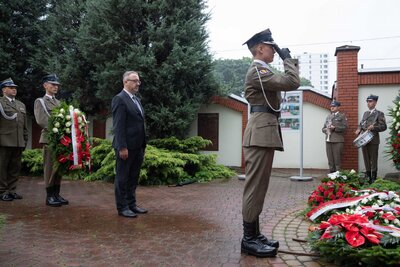 Dr hab. Karol Polejowski, zastępca prezesa IPN, składa kwiaty przed tablicą upamiętniającą ofiary rzezi Woli. Fot. Mikołaj Bujak