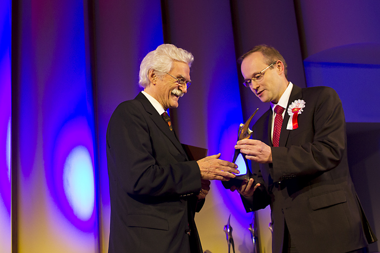 Prezes IPN dr. Łukasz Kamiński wręcza nagrodę Dieterowi Schenkowi