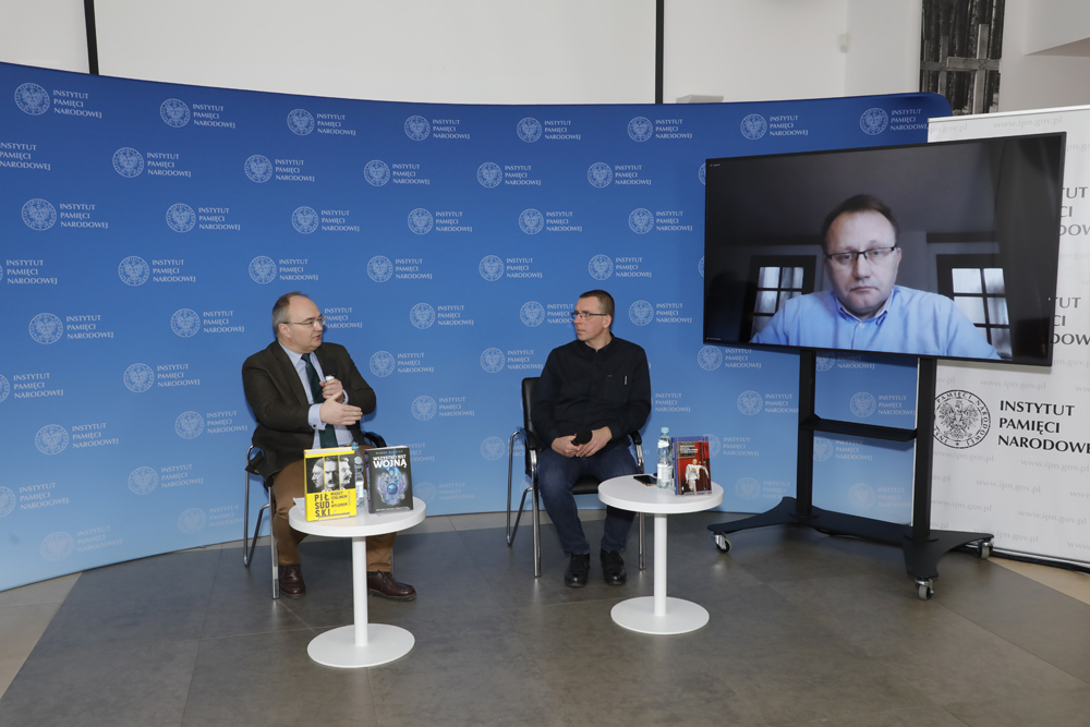 Dr Krzysztof Rak (L) i Rafał Dudkiewicz (P). Na ekranie Marek Budzisz. Dyskusja z cyklu „Historia zza kulis” – Warszawa, 28 marca 2022. Fot. Piotr Życieński (IPN)