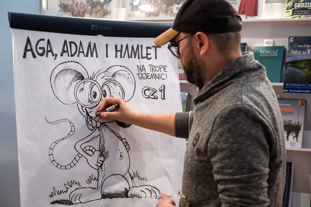 Hubert Ronek, twórca komiksowej serii #IPN „Wojenna odyseja Antka Srebrnego” rysuje i podpisuje – Targi Książki w Warszawie, 28 maja 2022. Fot. Sławek Kasper.