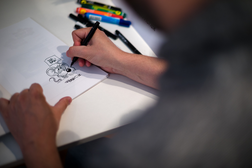 Hubert Ronek, twórca komiksowej serii #IPN „Wojenna odyseja Antka Srebrnego” rysuje i podpisuje – Targi Książki w Warszawie, 28 maja 2022. Fot. Sławek Kasper.