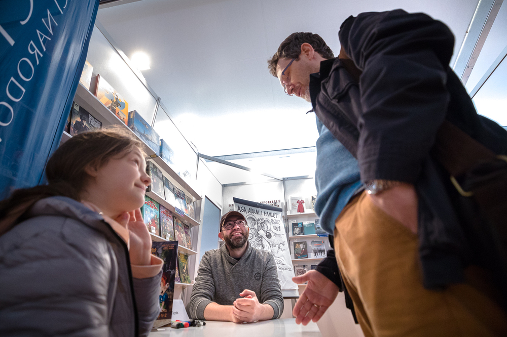 Hubert Ronek, twórca komiksowej serii #IPN „Wojenna odyseja Antka Srebrnego” rysuje i podpisuje – Targi Książki w Warszawie, 28 maja 2022. Fot. Sławek Kasper.