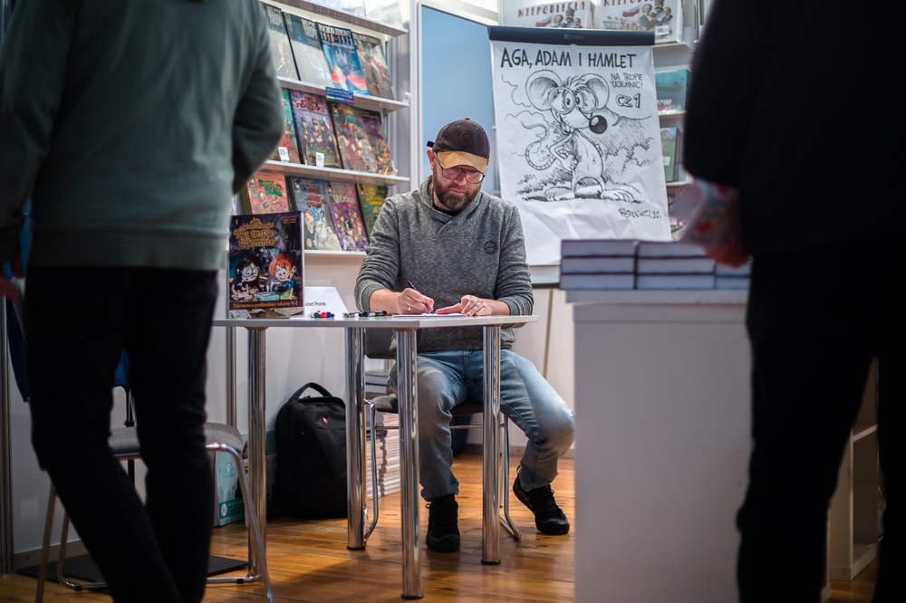 Hubert Ronek, twórca komiksowej serii #IPN „Wojenna odyseja Antka Srebrnego” rysuje i podpisuje – Targi Książki w Warszawie, 28 maja 2022. Fot. Sławek Kasper.
