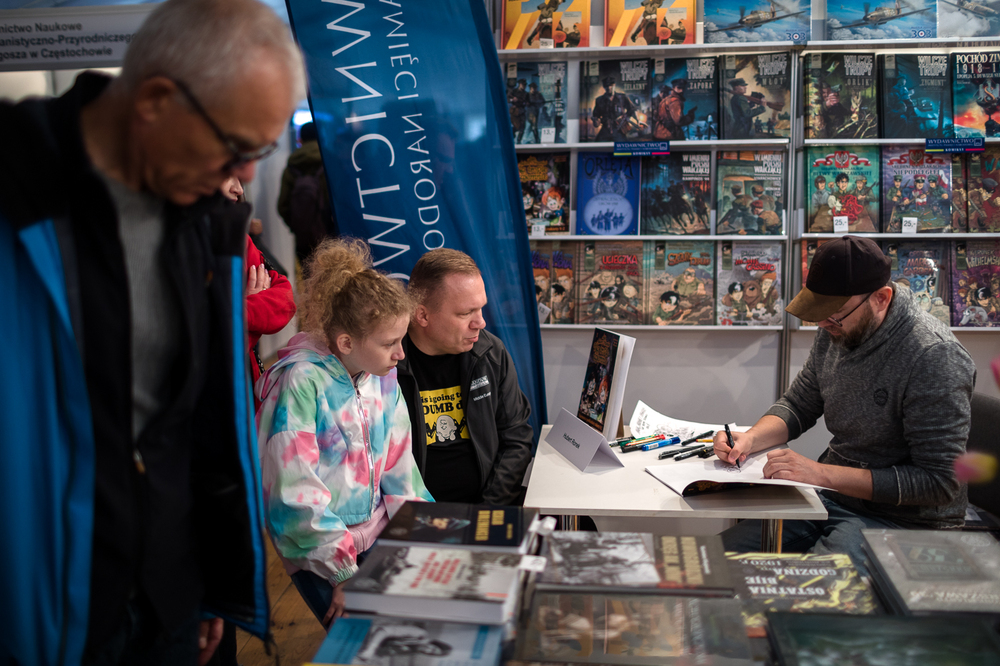 Hubert Ronek, twórca komiksowej serii #IPN „Wojenna odyseja Antka Srebrnego” rysuje i podpisuje – Targi Książki w Warszawie, 28 maja 2022. Fot. Sławek Kasper.
