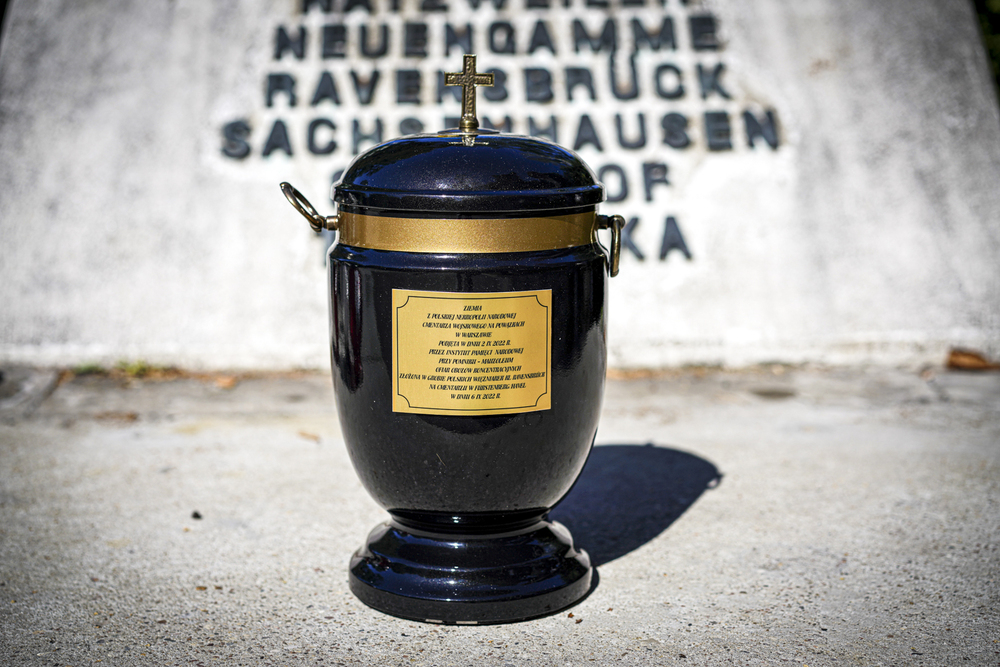 Ziemia z polskiej nekropoli narodowej Cmentarza Wojskowego na Powązkach w Warszawie podjęta w dniu 2.09.2022 r. przez Instytut Pamięci Narodowej przy Pomniku - Mauzoleum Ofiar Obozów Koncentracyjnych złożona w grobie polskich Więźniarek KL Ravensbrück na cmentarzu w Fürstenberg/Havel w dniu 06.09.2022