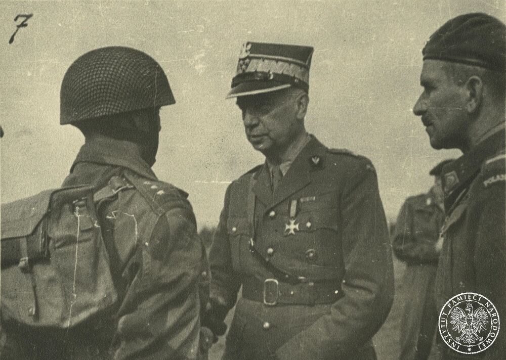 Wizyta gen. Kazimierza Sosnkowskiego w 1. Samodzielnej Brygadzie Spadochronowej. Gen. Sosnkowski (w środku) rozmawia z jednym z oficerów Brygady. Rozmowie przysłuchuje się płk Stanisław Sosabowski. Fot. z zasobu IPN