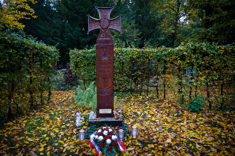 Złożenie kwiatów pod odnowionym staraniem IPN krzyżem na cmentarzu w Dachau – 15 października 2022. Fot. Sławek Kasper (IPN)