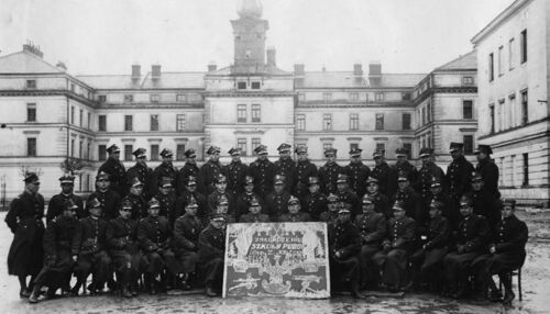 Pamiątka z ukończenia kursu Szkoły Podoficerskiej 20. Pułku Piechoty „Ziemi Krakowskiej”, 11 marca 1938 r. Trzeci od lewej w środkowym rzędzie stoi Stanisław Bielański. Wśród siedzących w pierwszym rzędzie przyszły dowódca plutonu ppanc. ppor. Julian Krzewicki (czwarty z lewej), dowódca 6. DP gen. Bernard Mond (dziewiąty z lewej, ponad tablicą, po prawej stronie), dowódca 20. PP „ZK” płk Kazimierz Brożek (na prawo od gen. Monda) i inni oficerowie 20. PP „ZK”. Fot. ze zbiorów Jerzego Krzewickiego