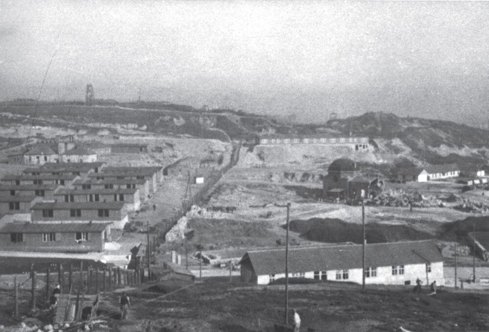 Panorama z wieży przeciwlotniczej. W dole Bergstrasse i ruiny domu przedpogrzebowego, wyżej SS-Lazaret, na prawo komendantura. Z lewej baraki mieszkalne dla Polaków, w środku linia ogrodzenia wewnętrznego oddzielająca część więźniarską od części niemieckiej (Fot. z Archiwum Instytutu Pamięci Narodowej)