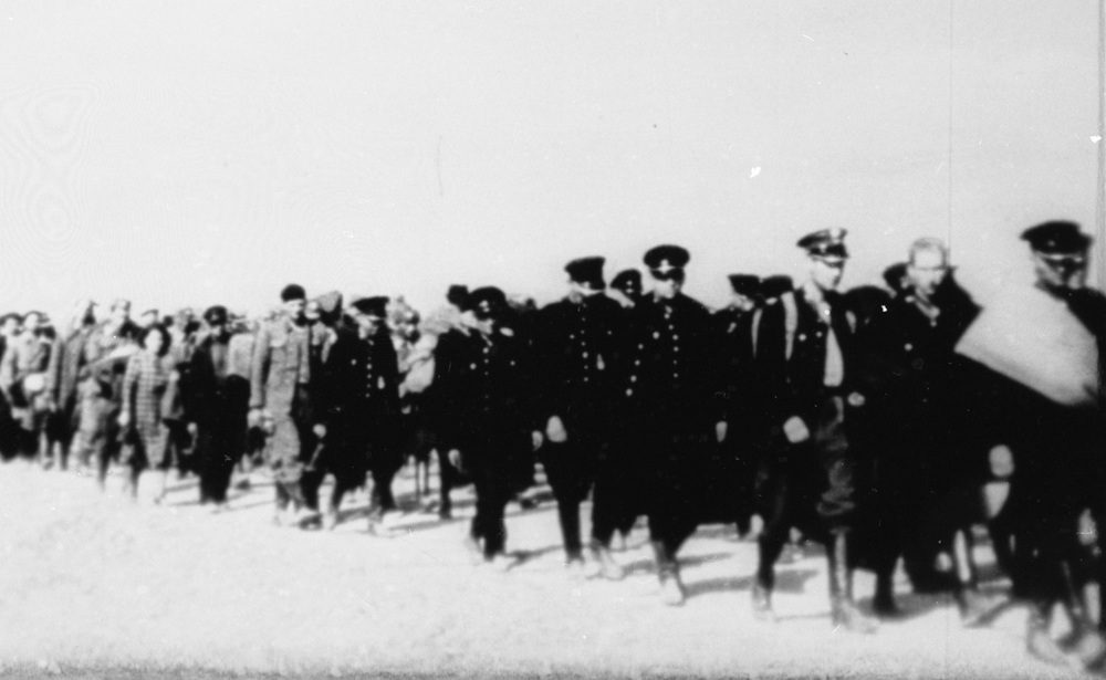 Kolumna polskich jeńców w niewoli sowieckiej (m.in. żołnierzy Wojska Polskiego i Korpusu Ochrony Pogranicza, funkcjonariuszy Policji Państwowej) i osób cywilnych. Fotokopia ze zbiorów AIPN, prawdopodobnie kadru z sowieckiego filmu propagandowego lub kroniki filmowej