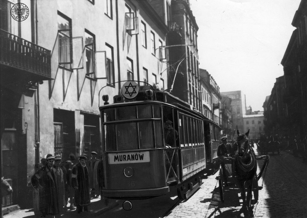 Tramwaj tylko dla Żydów, jadący w kierunku Muranowa ulicą getta w okupowanej Warszawie. Niemieckie zdjęcie propagandowe z okresu okupacji, wykonane prawdopodobnie na ul. Muranowskiej w kierunku skrzyżowania z ul. Zamenhofa. Widoczny retusz strojów postaci i elementów pojazdu. Warszawa, 1941 r. Autor: NN. Fot. z zasobu AIPN