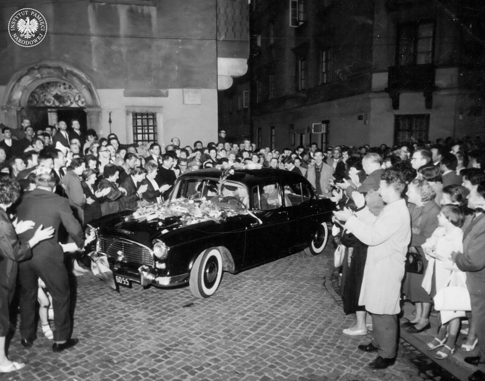 Obsypany kwiatami samochód wiozący wieczorem prymasa Stefana Wyszyńskiego pośród tłumu wiwatujących osób na Rynku Starego Miasta w Warszawie. Obchody Milenium Chrztu Polski w Warszawie, 26 VI 1966 r. (fot. z zasobu IPN)