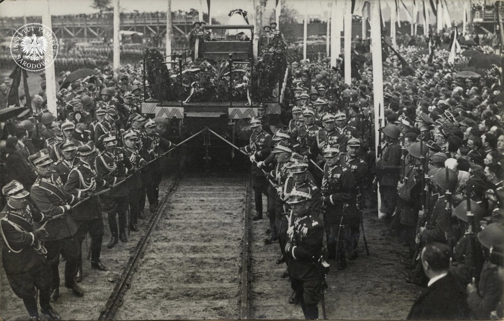 Ostatni akt pożegnania Józefa Piłsudskiego w stolicy, uroczystość na Polu Mokotowskim (obecnie park noszący imię Marszałka). Na zdjęciu generałowie Wojska Polskiego ciągnący platformę z trumną po torach przygotowanych specjalnie na tę okazję, prowadzących do stacji kolejowej. Warszawa, 17 maja 1935 r. Fot. z zasobu IPN