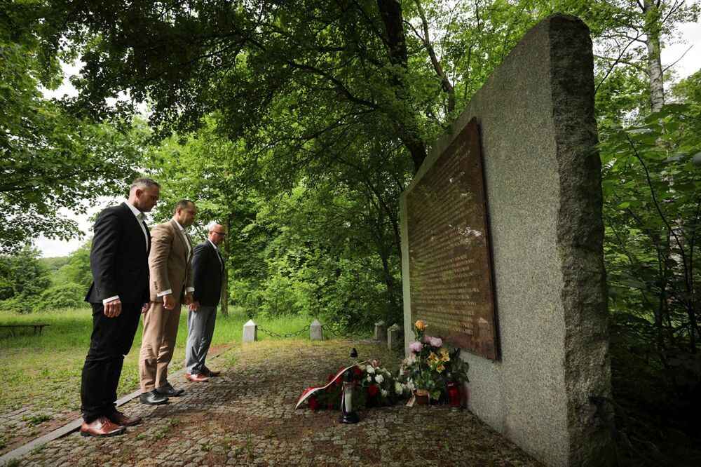 Dr Karol Nawrocki, prezes IPN, dr Marek Szymaniak, dyrektor gdańskiego IPN oraz jego zastępca Waldemar Szulc złożyli kwiaty przy tablicy w Dolinie Śmierci, upamiętniającej ofiary Zbrodni Pomorskiej, znajdującej się niedaleko miejsca prac poszukiwawczych – 23 maja 2024. Fot. Mikołaj Bujak (IPN)