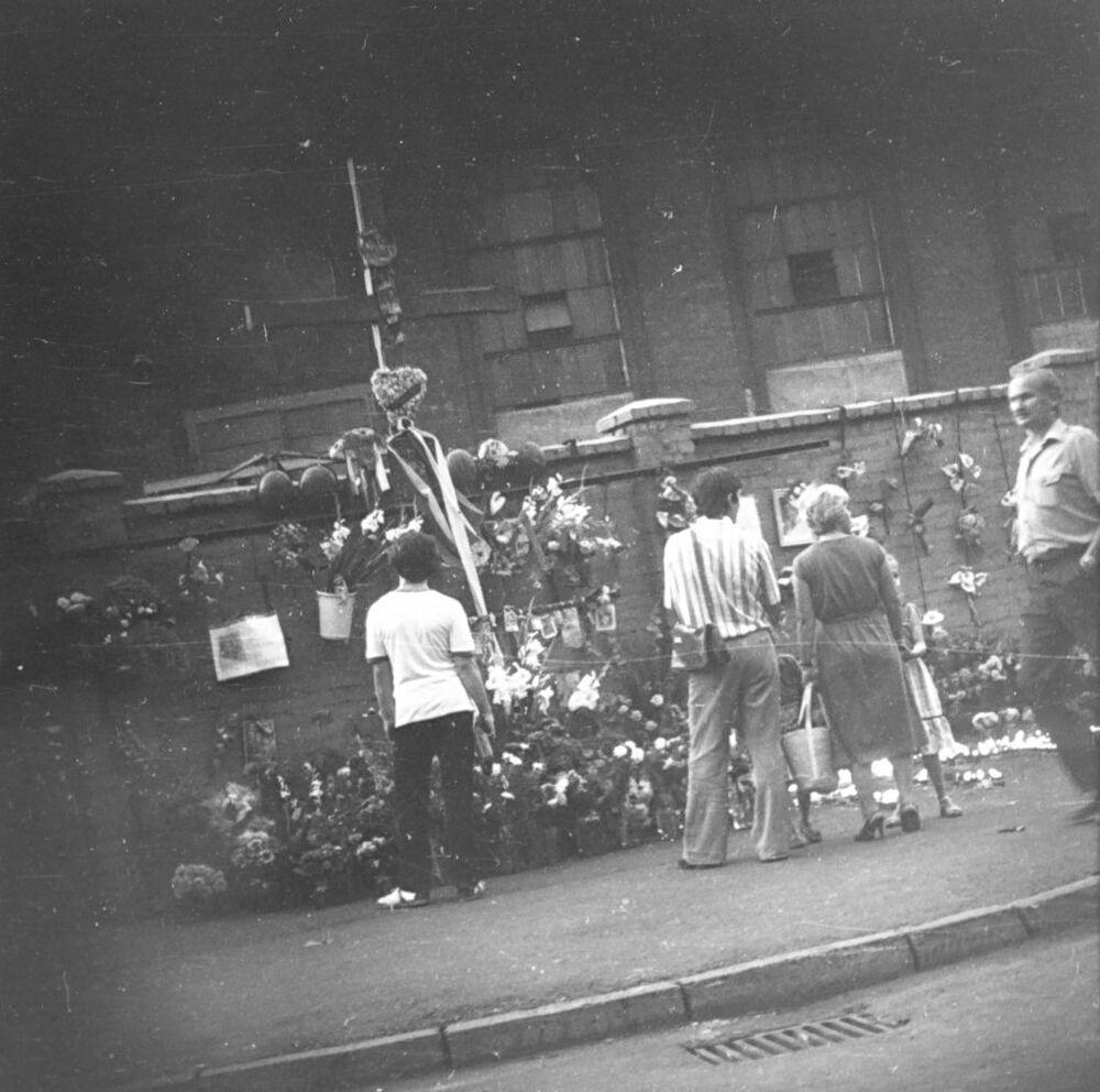 Obserwacja osób składających wieńce i kwiaty złożone pod drewnianym krzyżem upamiętniającym poległych górników KWK „Wujek” (AIPN Ka 435/58, k. 2)