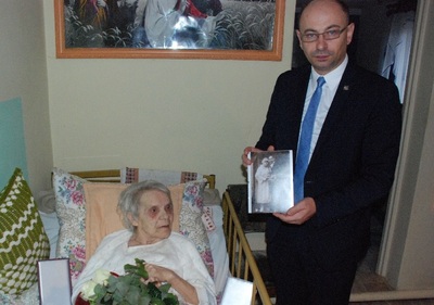 Zastępca Prezesa IPN dr Mateusz Szpytma prezentuje fotografię ślubną Państwa Kurpielów